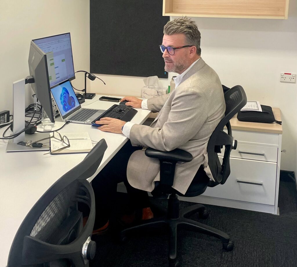 Stuart Hutcheon working at a desk in StewartBrown’s private office at Inspire Cowork Miranda